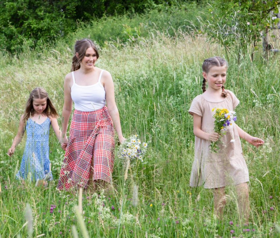 Woman and girls picking flowers in a meadow