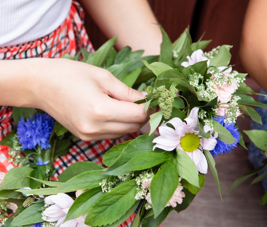 Woman making a wreath of midsummer flowers