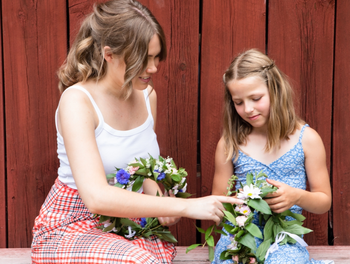 Woman teaches girl how to make a wreath